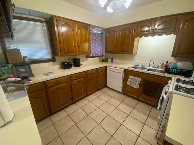 10721 Hermosa Dr, Dallas, TX 75218 - kitchen with white dishwasher, a sink, light countertops, light tile patterned floors, and gas range oven