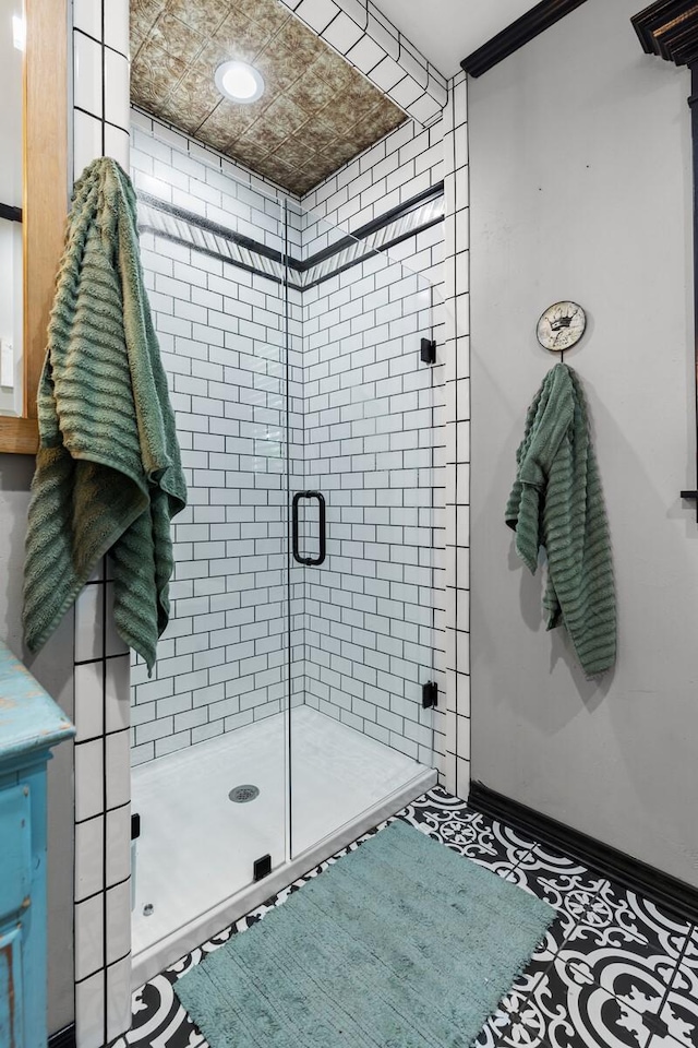 full bath with baseboards and a shower stall