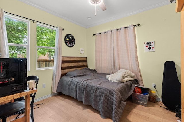 bedroom featuring crown molding, a ceiling fan, baseboards, and light wood finished floors
