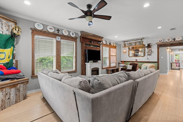 living room with recessed lighting, ornamental molding, and light wood-style flooring
