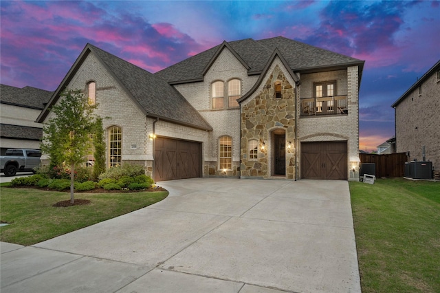 2308 Topaz Dr, Rockwall, TX 75087 - french country style house featuring a lawn, driveway, brick siding, and a balcony