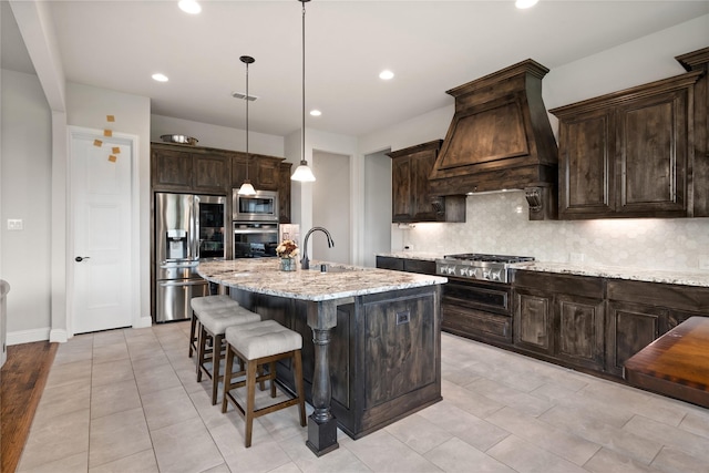 2308 Topaz Dr, Rockwall, TX 75087 - kitchen featuring appliances with stainless steel finishes, backsplash, premium range hood, and dark brown cabinetry