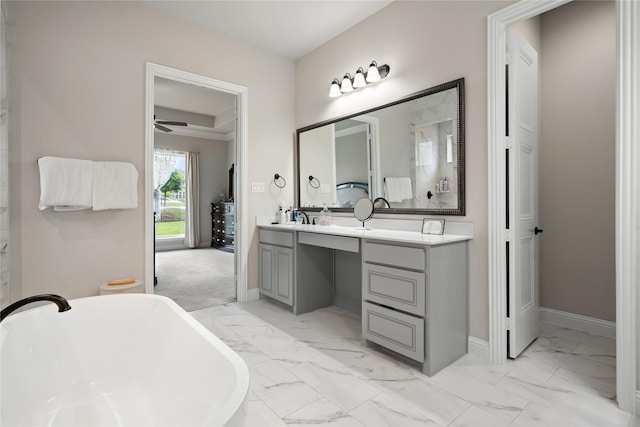 2308 Topaz Dr, Rockwall, TX 75087 - bathroom with a ceiling fan, a freestanding bath, vanity, baseboards, and marble finish floor