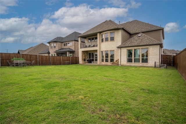2308 Topaz Dr, Rockwall, TX 75087 - back of house featuring brick siding, a fenced backyard, a balcony, a yard, and a shingled roof