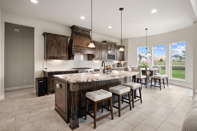 2308 Topaz Dr, Rockwall, TX 75087 - kitchen featuring visible vents, dark brown cabinets, baseboards, tasteful backsplash, and a sink