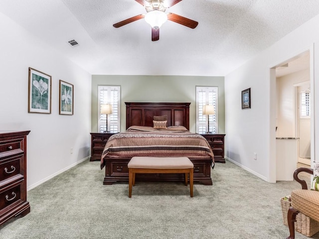 bedroom with light colored carpet, a ceiling fan, a textured ceiling, and baseboards