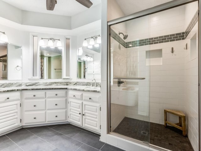 full bath featuring a stall shower, tile patterned flooring, vanity, and a ceiling fan