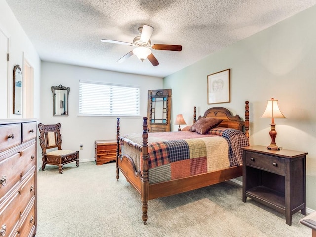 bedroom with light carpet, ceiling fan, baseboards, and a textured ceiling