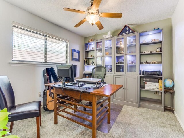 office area featuring a ceiling fan, light carpet, a textured ceiling, and baseboards