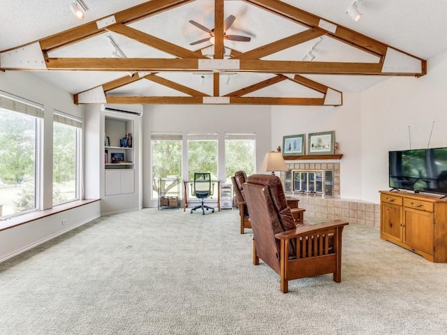 living room featuring track lighting, carpet flooring, a wall unit AC, a tile fireplace, and ceiling fan