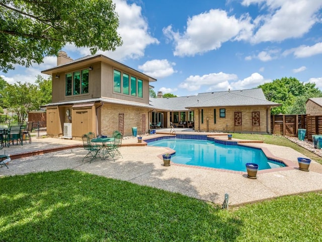 back of property featuring a chimney, a patio, and brick siding