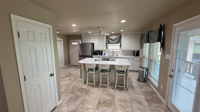 407 S Lakewood Cir, Lake Bridgeport, TX 76426 - kitchen featuring freestanding refrigerator, light countertops, healthy amount of natural light, white cabinets, and recessed lighting