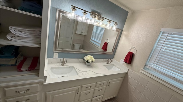 407 S Lakewood Cir, Lake Bridgeport, TX 76426 - bathroom featuring a textured wall, toilet, and double vanity