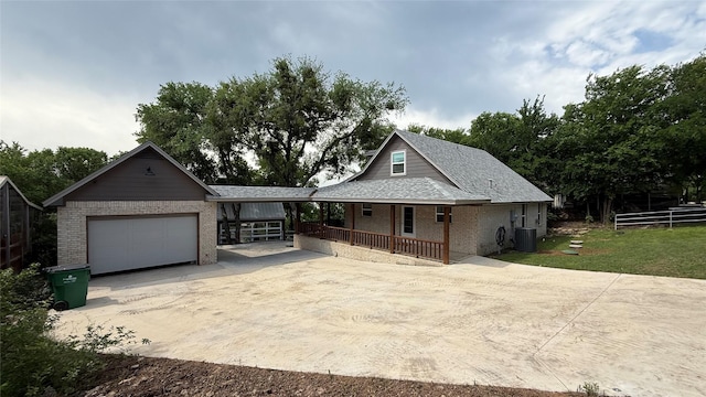 407 S Lakewood Cir, Lake Bridgeport, TX 76426 - view of front of home featuring a porch, brick siding, concrete driveway, central AC unit, and an attached garage