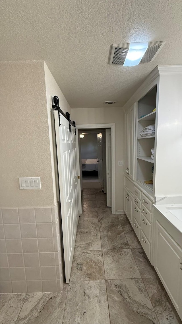 407 S Lakewood Cir, Lake Bridgeport, TX 76426 - hall with a textured ceiling and a barn door