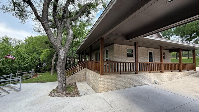 407 S Lakewood Cir, Lake Bridgeport, TX 76426 - view of property exterior featuring brick siding, a patio, a porch, and a yard
