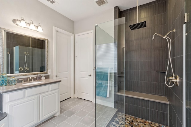bathroom with visible vents, walk in shower, tile patterned flooring, and vanity
