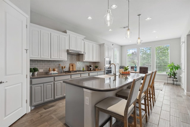 kitchen featuring a sink, stainless steel appliances, recessed lighting, and under cabinet range hood