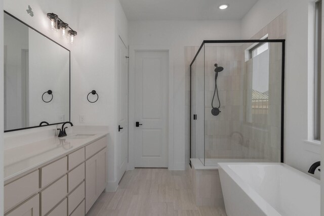 bathroom with vanity, recessed lighting, a soaking tub, and a stall shower