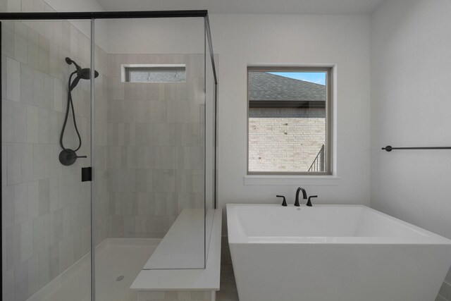 full bathroom with a freestanding bath, plenty of natural light, and a shower stall