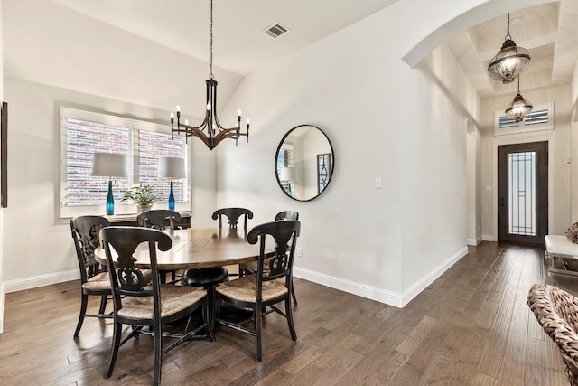 dining room featuring dark wood-style flooring, a notable chandelier, arched walkways, baseboards, and lofted ceiling