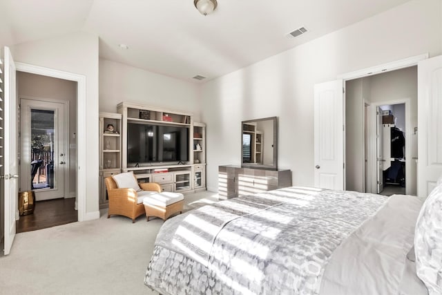 bedroom featuring carpet flooring, lofted ceiling, and visible vents