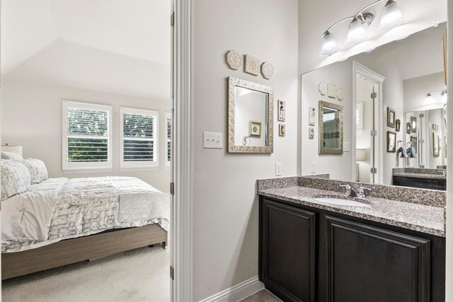 bathroom with ensuite bathroom, baseboards, and vanity