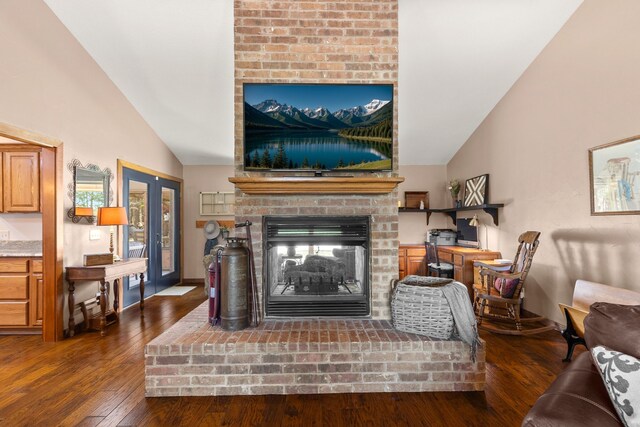 living area with wood finished floors, vaulted ceiling, and a fireplace