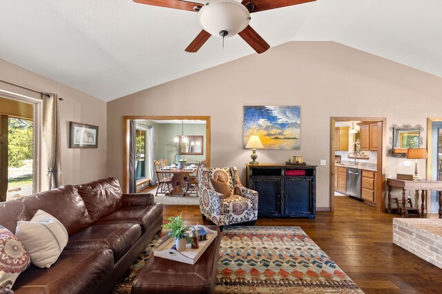living area featuring dark wood-type flooring, ceiling fan with notable chandelier, and vaulted ceiling