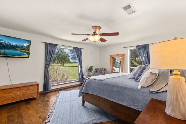 bedroom with visible vents, ceiling fan, wood finished floors, and multiple windows