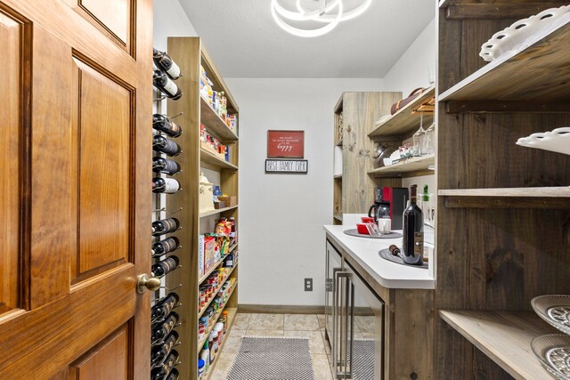wine cellar featuring baseboards, light tile patterned floors, and beverage cooler