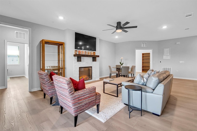 living room featuring a ceiling fan, light wood-style flooring, and visible vents