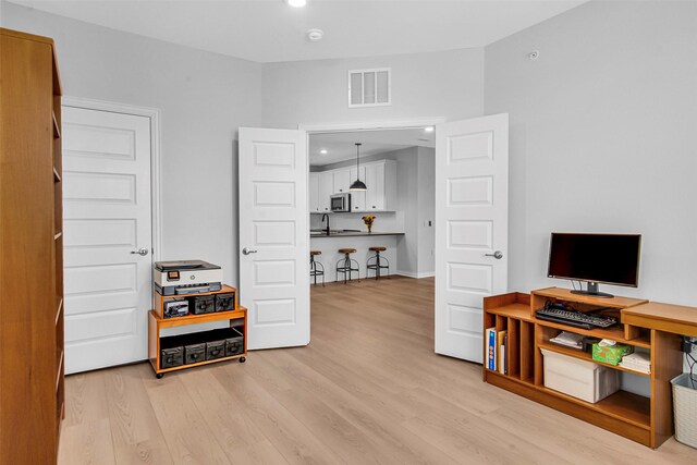 office space featuring recessed lighting, light wood finished floors, and visible vents