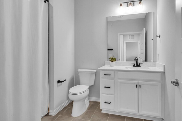 bathroom with visible vents, vanity, toilet, baseboards, and tile patterned floors