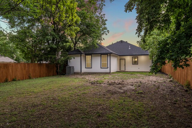 518 S Cockrell Hill Rd, Cockrell Hill, TX 75211 - back of house with a lawn, a shingled roof, central AC unit, and a fenced backyard