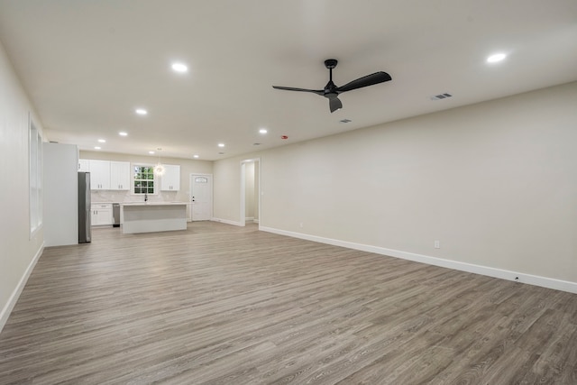 518 S Cockrell Hill Rd, Cockrell Hill, TX 75211 - unfurnished living room featuring baseboards, light wood finished floors, a ceiling fan, and recessed lighting