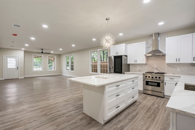 518 S Cockrell Hill Rd, Cockrell Hill, TX 75211 - kitchen featuring wall chimney range hood, a notable chandelier, appliances with stainless steel finishes, a center island, and visible vents
