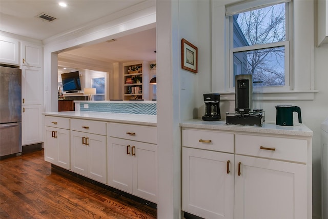 1635 Taft St, Dallas, TX 75208 - interior space featuring freestanding refrigerator, visible vents, dark wood finished floors, white cabinetry, and light countertops