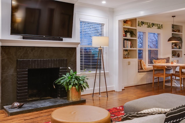 1635 Taft St, Dallas, TX 75208 - living room featuring built in shelves, wood finished floors, ornamental molding, and a high end fireplace