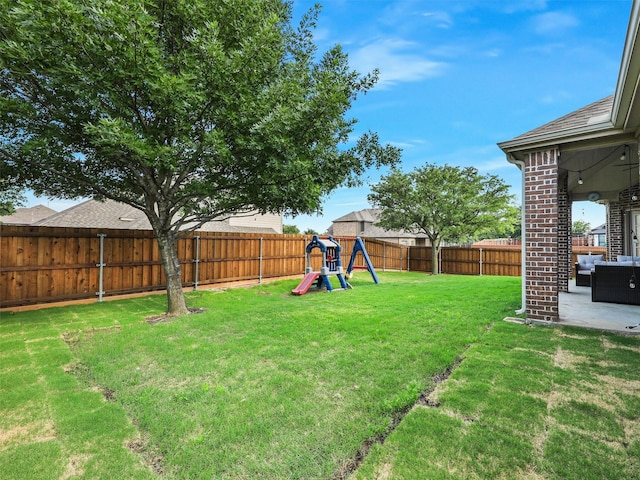 view of yard with a fenced backyard, a patio area, and a playground