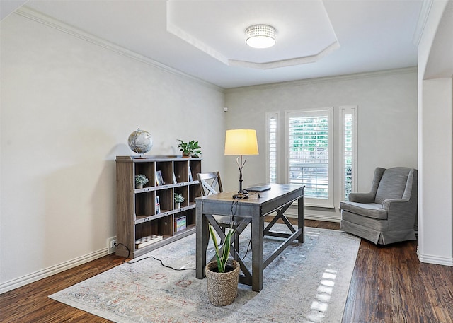 office area featuring baseboards, ornamental molding, wood finished floors, and a tray ceiling