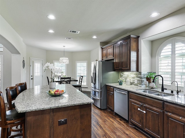 kitchen featuring dark wood-style flooring, appliances with stainless steel finishes, a sink, a healthy amount of sunlight, and visible vents