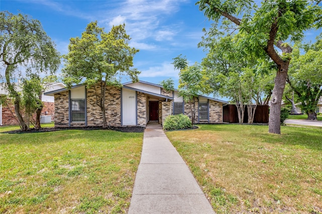 mid-century inspired home with fence and a front lawn