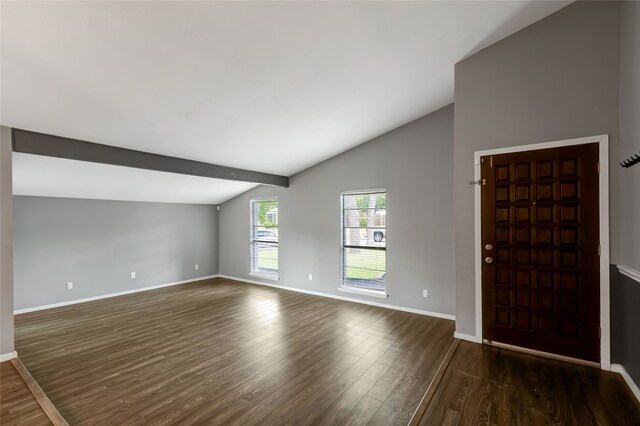 foyer entrance featuring dark wood-type flooring, baseboards, and vaulted ceiling
