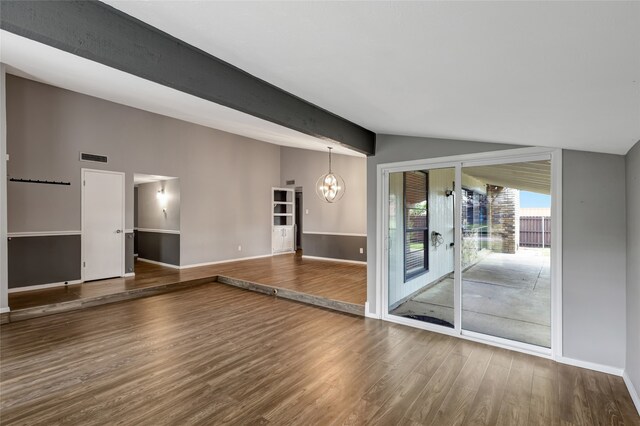 unfurnished living room featuring visible vents, wood finished floors, baseboards, vaulted ceiling with beams, and a notable chandelier