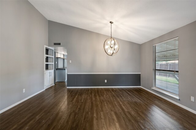 empty room with an inviting chandelier, visible vents, dark wood finished floors, baseboards, and vaulted ceiling