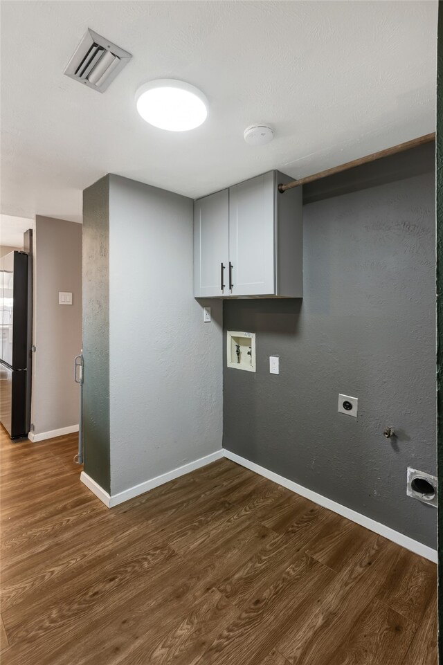 clothes washing area with visible vents, cabinet space, washer hookup, and dark wood-style floors