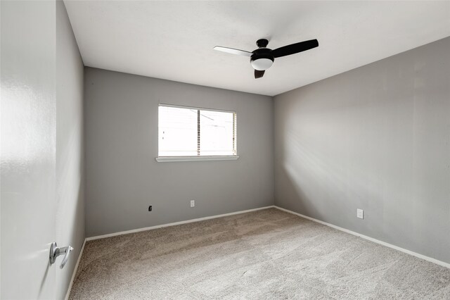 spare room featuring baseboards, a ceiling fan, and carpet
