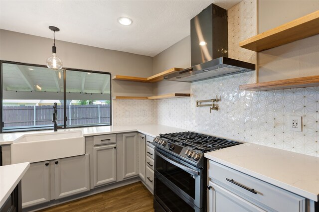 kitchen with exhaust hood, double oven range, open shelves, a sink, and dark wood-type flooring