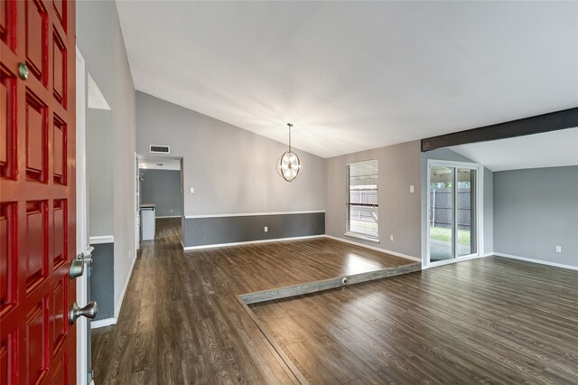 interior space featuring dark wood-style flooring, visible vents, vaulted ceiling, baseboards, and an inviting chandelier